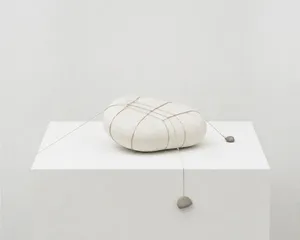 Tensioned symmetry with stone and string