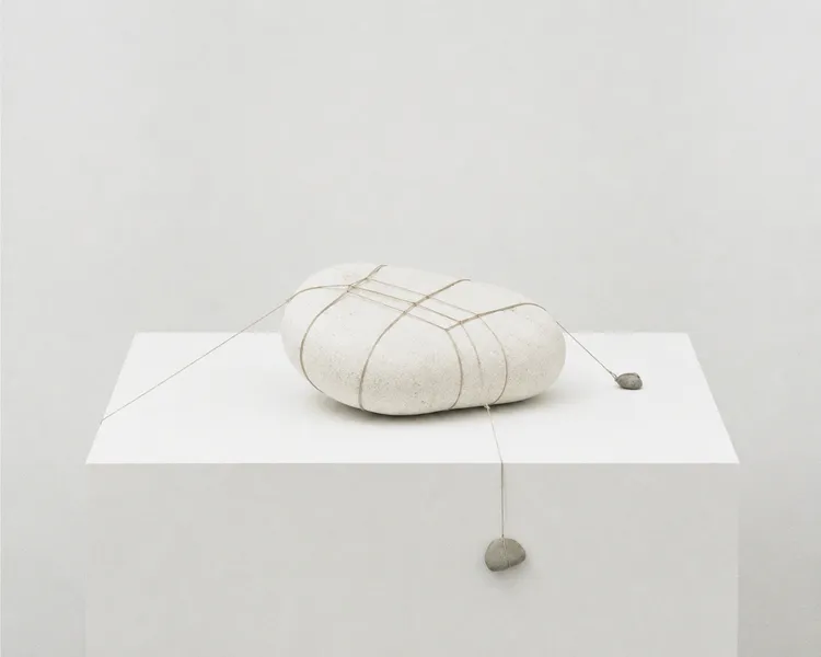 Tensioned symmetry with stone and string
